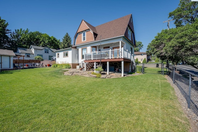 rear view of property featuring a gate, a lawn, a fenced backyard, and a shingled roof