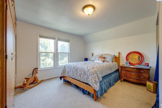 bedroom with baseboards, light carpet, and vaulted ceiling