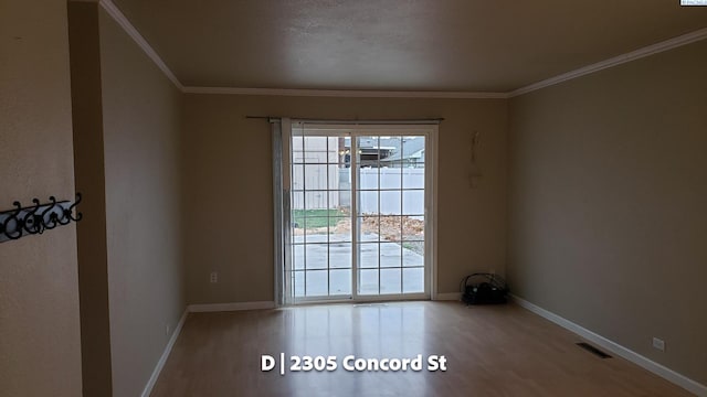 empty room featuring crown molding and hardwood / wood-style floors