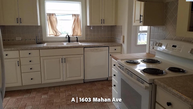 kitchen with white cabinetry, sink, white appliances, and a wealth of natural light