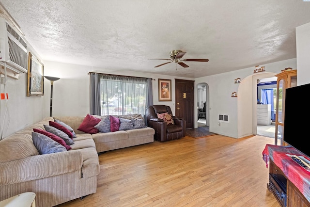 506 S Zillah St, Kennewick, WA 99336 - living room featuring arched walkways, healthy amount of natural light, a ceiling fan, light wood-type flooring, and a textured ceiling