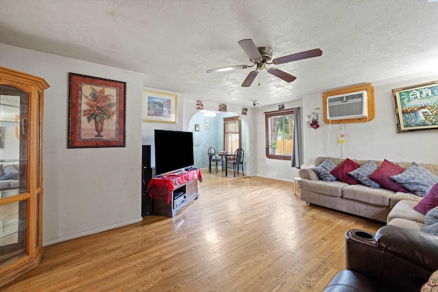 506 S Zillah St, Kennewick, WA 99336 - living area with light wood-style flooring, a textured ceiling, ceiling fan, an AC wall unit, and arched walkways