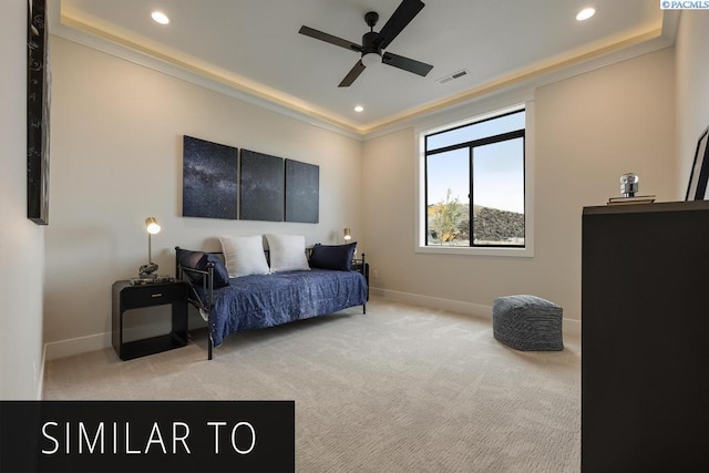 carpeted bedroom featuring ceiling fan and a tray ceiling