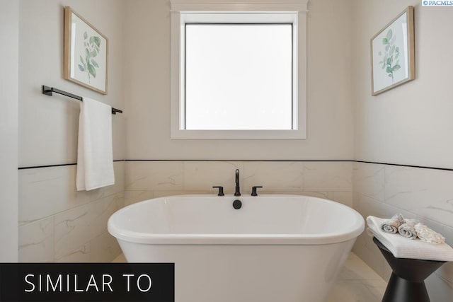 bathroom featuring tile walls and a bathtub