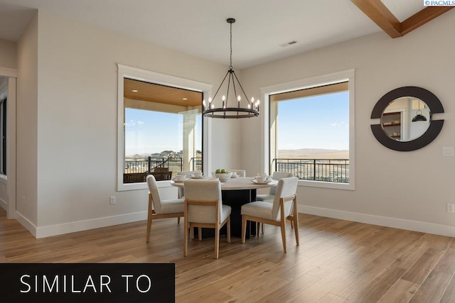 dining room featuring beam ceiling, a notable chandelier, and light wood-type flooring