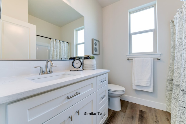 6482 W 30th Pl, Kennewick, WA 99338 - full bathroom with vanity, toilet, wood finished floors, baseboards, and a shower with shower curtain