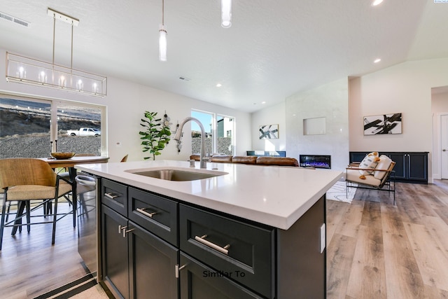 6482 W 30th Pl, Kennewick, WA 99338 - kitchen with a sink, lofted ceiling, a tiled fireplace, light wood-style floors, and light countertops