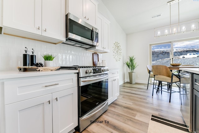 6482 W 30th Pl, Kennewick, WA 99338 - kitchen featuring appliances with stainless steel finishes, decorative backsplash, light wood-style flooring, light countertops, and white cabinets