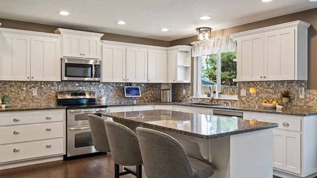 1824 W 28th Ave, Kennewick, WA 99337 - kitchen featuring appliances with stainless steel finishes, dark wood-type flooring, a center island, recessed lighting, and white cabinets