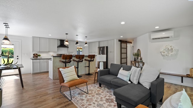 654 Cottonwood Dr, Richland, WA 99352 - living room with a barn door, a wall mounted AC, light wood-style flooring, recessed lighting, and baseboards