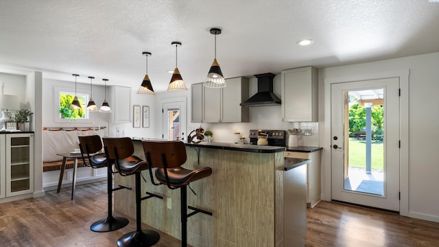 654 Cottonwood Dr, Richland, WA 99352 - kitchen with wall chimney exhaust hood, healthy amount of natural light, dark wood-style floors, a kitchen breakfast bar, and a textured ceiling