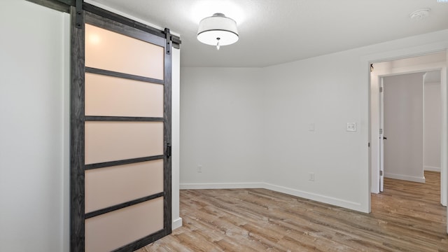 654 Cottonwood Dr, Richland, WA 99352 - empty room featuring wood finished floors, a barn door, a smoke detector, and baseboards
