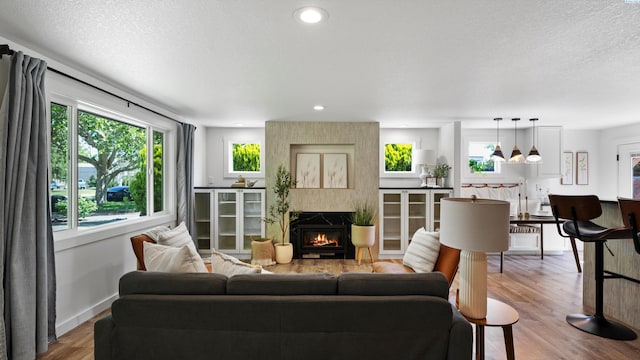 654 Cottonwood Dr, Richland, WA 99352 - living room with a fireplace, wood finished floors, healthy amount of natural light, a textured ceiling, and baseboards