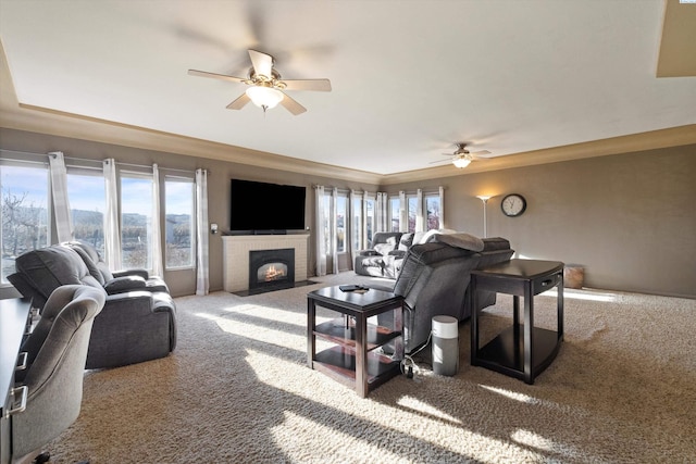 living room with a fireplace, ceiling fan, and carpet