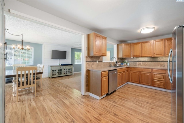 2519 W Grand Rhonde Pl, Kennewick, WA 99336 - kitchen featuring stainless steel appliances, light wood-type flooring, light countertops, a sink, and tasteful backsplash