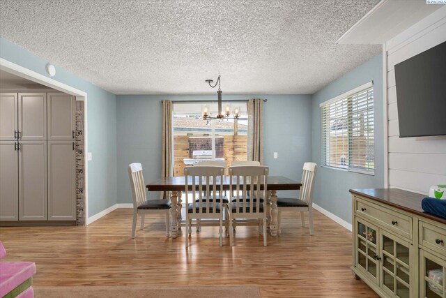 2519 W Grand Rhonde Pl, Kennewick, WA 99336 - dining area featuring a chandelier, light wood-style flooring, a textured ceiling, and baseboards