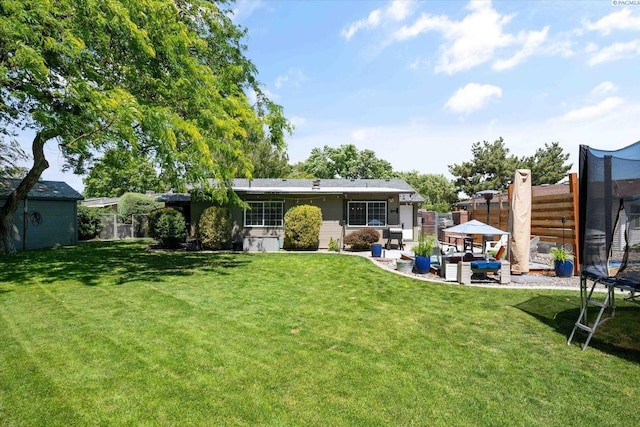2519 W Grand Rhonde Pl, Kennewick, WA 99336 - back of property featuring a trampoline, a patio area, and outdoor lounge area