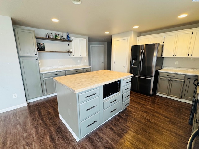 kitchen featuring gray cabinets, wood counters, dark hardwood / wood-style flooring, a center island, and stainless steel refrigerator with ice dispenser