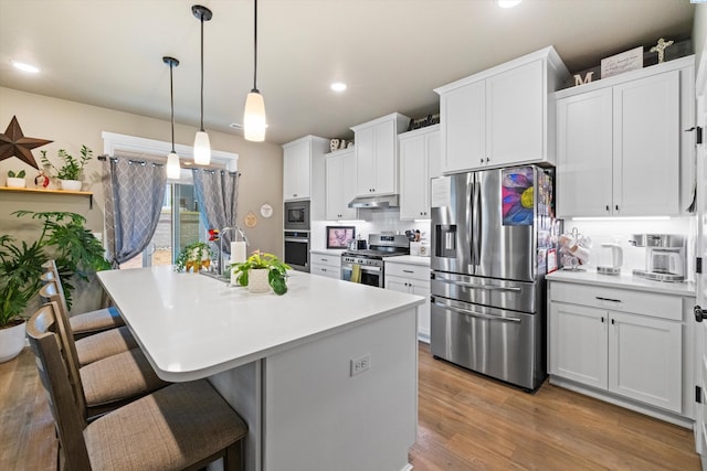 7867 Blanchard Loop, West Richland, WA 99353 - kitchen with stainless steel appliances, white cabinetry, a breakfast bar, light countertops, and recessed lighting