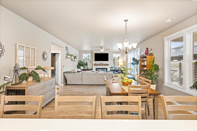 7867 Blanchard Loop, West Richland, WA 99353 - dining room featuring wood finished floors, a fireplace, and a chandelier