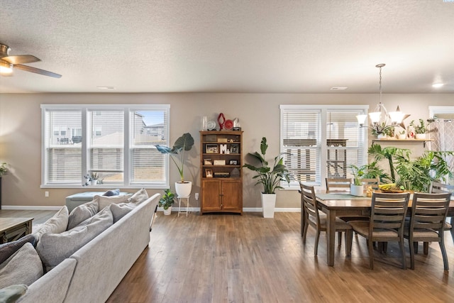 7867 Blanchard Loop, West Richland, WA 99353 - living room featuring hardwood / wood-style flooring, a chandelier, ceiling fan, and a textured ceiling
