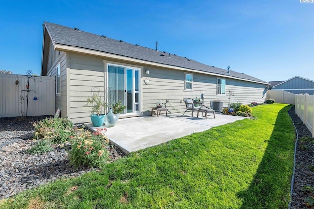 back of property with central AC unit, a patio area, and a lawn