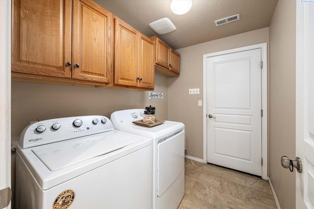 laundry room featuring cabinets and separate washer and dryer