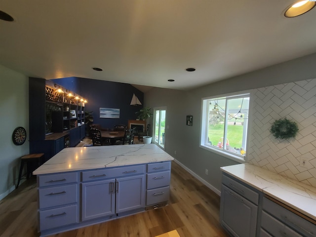 7218 W 15th Ave, Kennewick, WA 99336 - kitchen with light wood-type flooring, baseboards, light stone counters, decorative backsplash, and blue cabinets