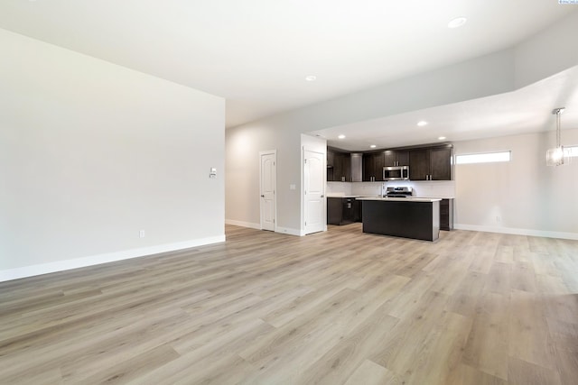 10402 Kokanee Dr, Pasco, WA 99301 - unfurnished living room featuring light wood-style floors, recessed lighting, an inviting chandelier, and baseboards