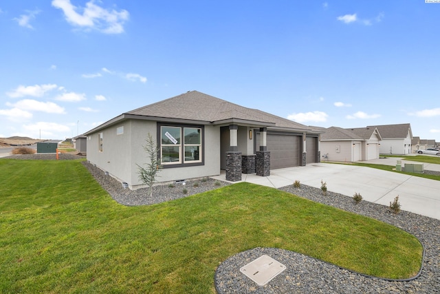 prairie-style home featuring a garage, a shingled roof, concrete driveway, stucco siding, and a front yard