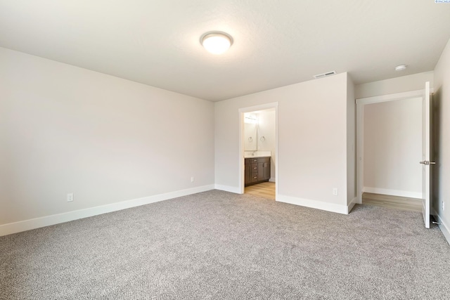 10402 Kokanee Dr, Pasco, WA 99301 - unfurnished bedroom featuring baseboards, visible vents, connected bathroom, and light colored carpet