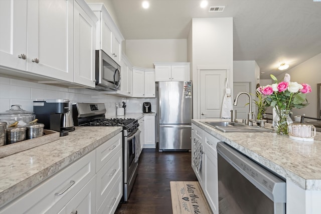 kitchen featuring white cabinetry, appliances with stainless steel finishes, sink, and tasteful backsplash