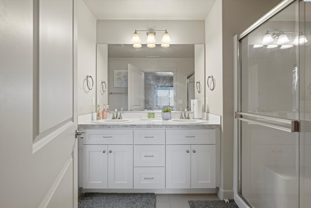 bathroom with a shower with door, tile patterned flooring, and vanity