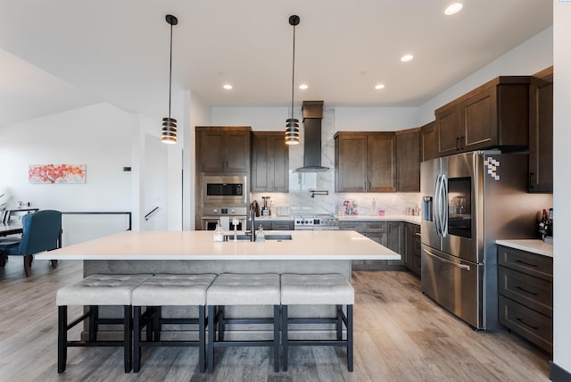 3312 Bing St, West Richland, WA 99353 - kitchen with wall chimney exhaust hood, appliances with stainless steel finishes, light wood-style flooring, light countertops, and a sink