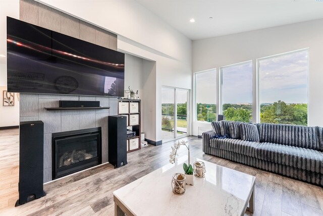 3312 Bing St, West Richland, WA 99353 - living area with a tile fireplace, wood finished floors, recessed lighting, a towering ceiling, and baseboards