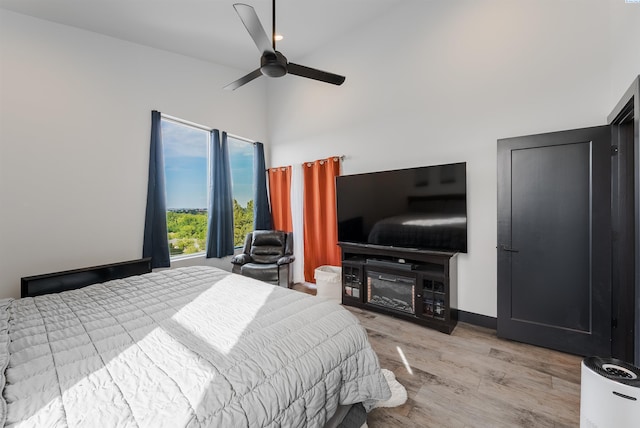 3312 Bing St, West Richland, WA 99353 - bedroom with light wood-type flooring, a towering ceiling, a fireplace, a ceiling fan, and baseboards