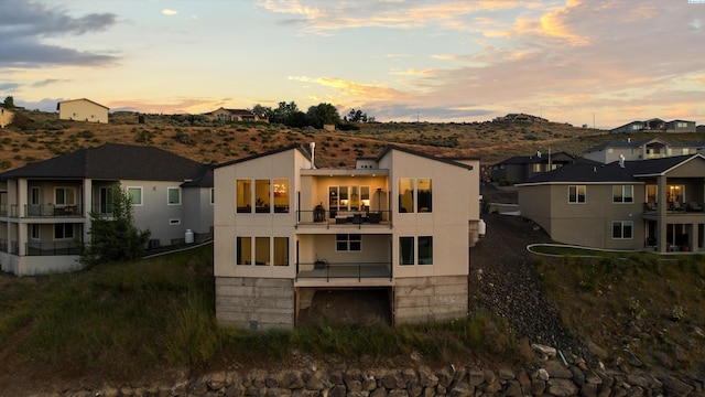 3312 Bing St, West Richland, WA 99353 - back of property at dusk featuring a balcony, a residential view, a mountain view, and stucco siding