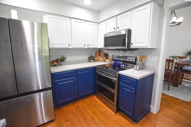 2780 Katie Rd, Kennewick, WA 99338 - kitchen with appliances with stainless steel finishes, blue cabinets, light wood-style floors, white cabinetry, and recessed lighting