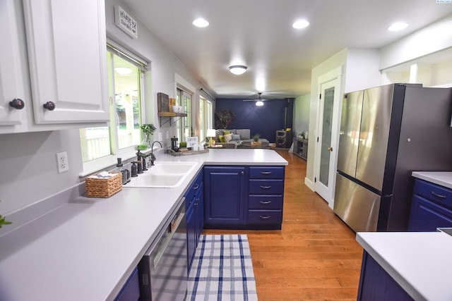 2780 Katie Rd, Kennewick, WA 99338 - kitchen with a sink, appliances with stainless steel finishes, light countertops, blue cabinetry, and a peninsula