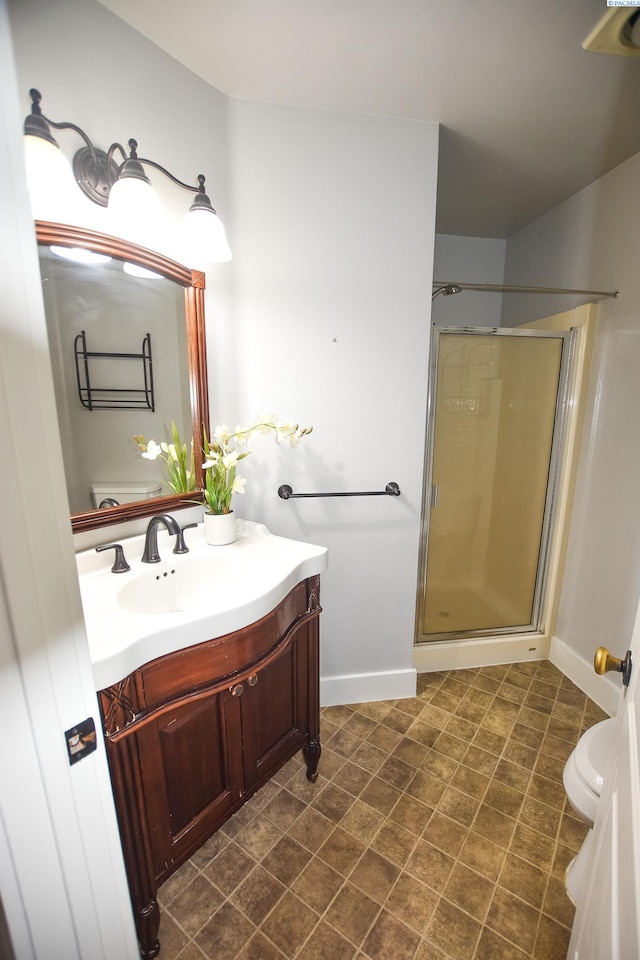 2780 Katie Rd, Kennewick, WA 99338 - full bathroom featuring vanity, a stall shower, toilet, and baseboards