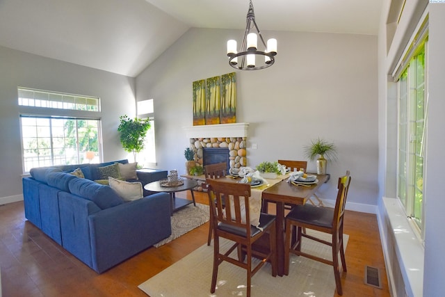 2780 Katie Rd, Kennewick, WA 99338 - living area with a stone fireplace, wood finished floors, baseboards, a chandelier, and high vaulted ceiling