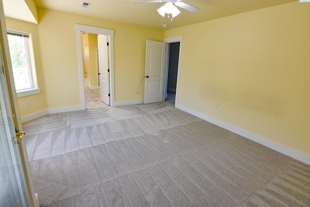 unfurnished bedroom with ensuite bath, baseboards, visible vents, and carpet floors