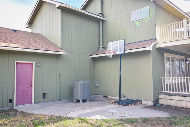 back of property with roof with shingles, a balcony, central AC, and a patio area
