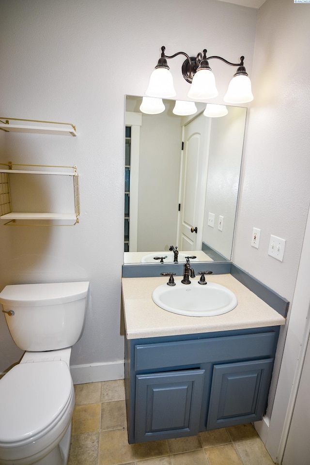 bathroom featuring vanity, baseboards, and toilet