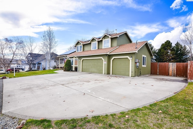 view of front of house featuring roof with shingles, concrete driveway, and fence
