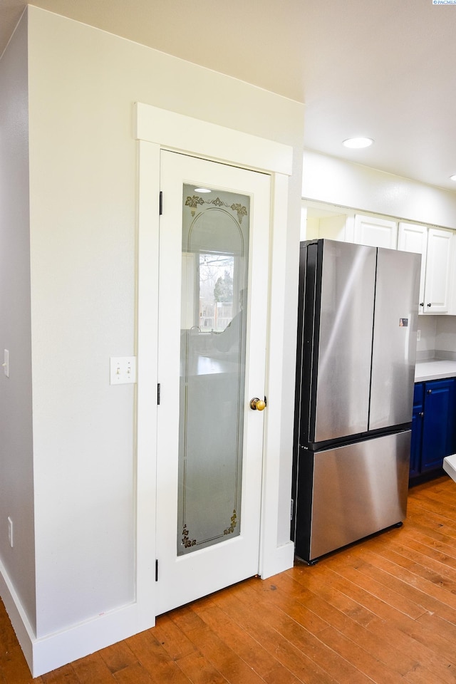 2780 Katie Rd, Kennewick, WA 99338 - kitchen featuring freestanding refrigerator, blue cabinetry, light wood-style floors, recessed lighting, and white cabinets