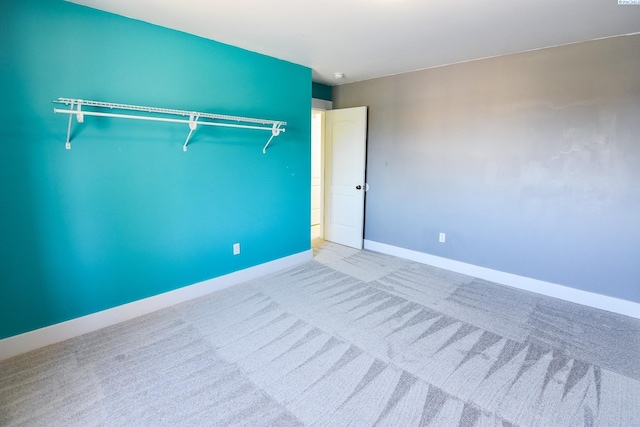 carpeted spare room featuring baseboards