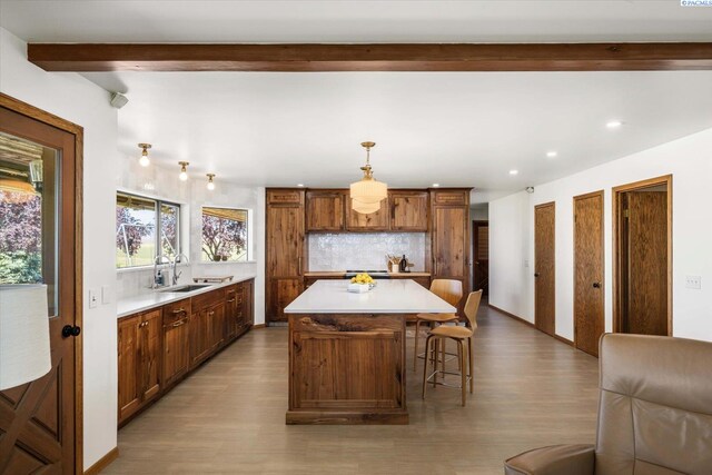 170732 Olsen Rd, Grandview, WA 98930 - kitchen with wood finished floors, tasteful backsplash, beamed ceiling, light countertops, and a kitchen island