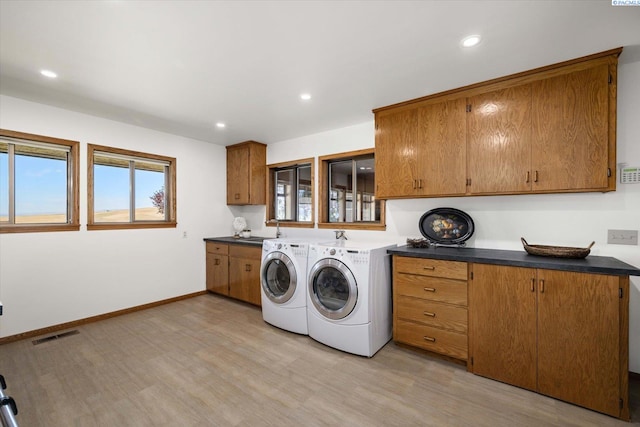 170732 Olsen Rd, Grandview, WA 98930 - laundry area featuring washing machine and dryer, light wood finished floors, recessed lighting, and cabinet space