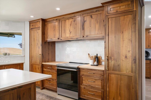 170732 Olsen Rd, Grandview, WA 98930 - kitchen featuring electric range oven, brown cabinets, tasteful backsplash, light countertops, and recessed lighting